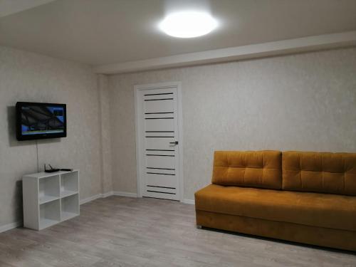 un soggiorno con divano e TV di Apartments on Dubrovinskogo a Krasnoyarsk
