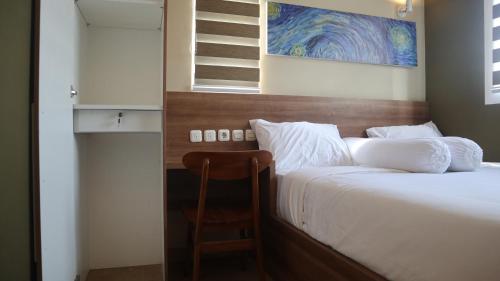a bedroom with a large bed with a wooden headboard at DJURAGAN KAMAR SLIPI in Jakarta