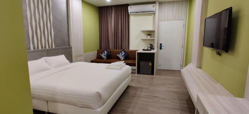 um quarto com uma grande cama branca e uma televisão em หอพัก ทูเอ็มเพลส 2M Place Apartment em Ban Khlong Nung