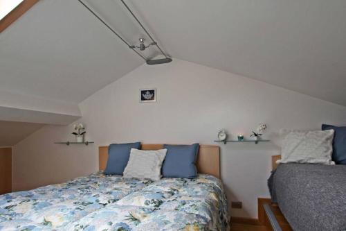 a bedroom with a bed with blue pillows at Wonderful Attic in Dolomite's Heart in Selva di Cadore