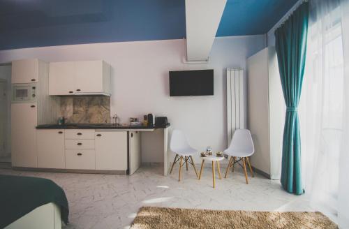 um quarto com uma cozinha, uma cama e uma mesa em NaFi Studio em Mamaia Nord – Năvodari
