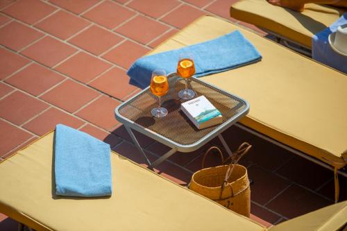 two tables with wine glasses and a cake on a table at Hotel Casa Albertina in Positano