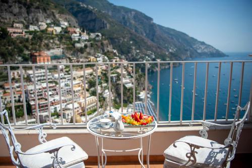 a table with a bowl of fruit on top of a balcony at Hotel Casa Albertina in Positano