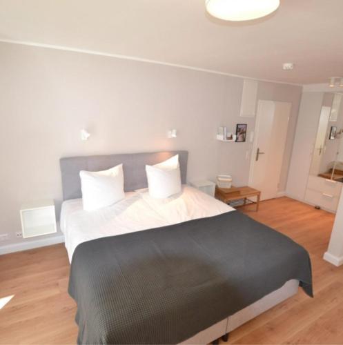 1 dormitorio con 1 cama grande con manta negra en Appartement-5-Kurviertel, en Westerland