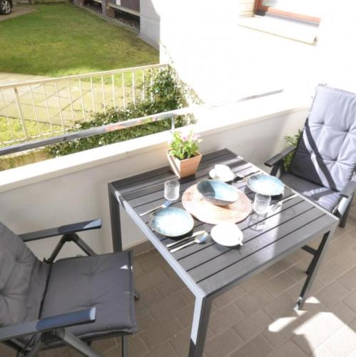 una mesa y sillas en un balcón con vistas a un patio en Appartement-5-Kurviertel, en Westerland