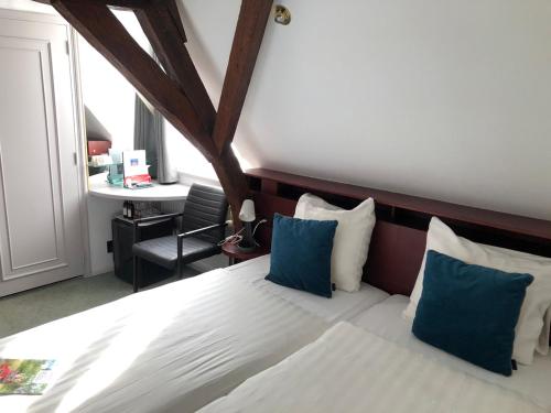 a bedroom with a large bed with blue pillows at In den Verdwaalde Koogel in Heusden