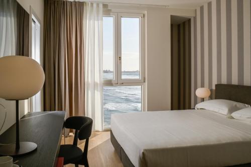 pokój hotelowy z łóżkiem i dużym oknem w obiekcie Hotel Punta Tipa w Trapani