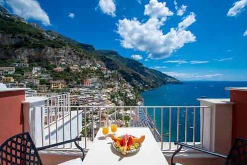 a table on a balcony with a view of the ocean at Hotel Casa Albertina in Positano