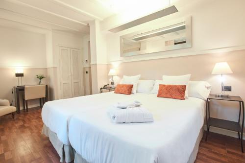 a bedroom with a large white bed in a room at U-Sense Sevilla Centro in Seville