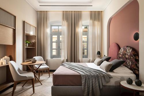 a bedroom with a bed and a table and chairs at Malmo Historic Hotel in Chania Town