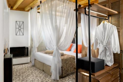 a bedroom with a canopy bed with white curtains at Elakati Luxury Boutique Hotel - Adults Only in Rhodes Town