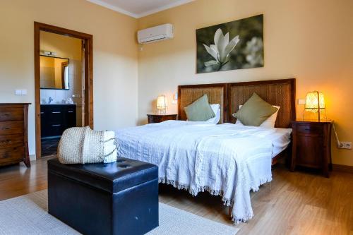 ein Schlafzimmer mit einem großen Bett mit einer weißen Blume an der Wand in der Unterkunft Moderne Finca Can Vicento - Heizung - Pizzaofen in Porto Cristo