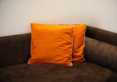 an orange pillow sitting on a brown couch at Hotel Bellavista Locarno in Locarno
