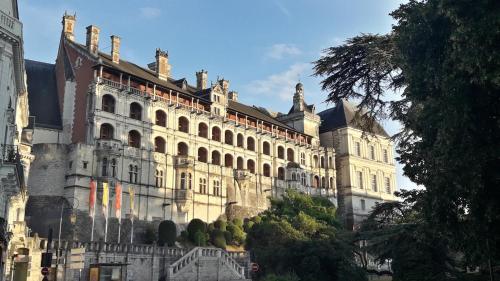 a large white building with a roof at LOIRE VELO 3 Appartements Moderne Vélo Parking 20 places vélos Centre Ville Historique Blois in Blois