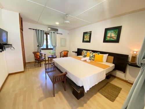 ein Schlafzimmer mit einem großen Bett in einem Zimmer in der Unterkunft Chalets de Palma in La Digue