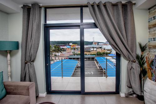 Cette chambre dispose d'une grande fenêtre offrant une vue sur la piscine. dans l'établissement Stay at the Point - Luxurious Lavish Looker, à Durban