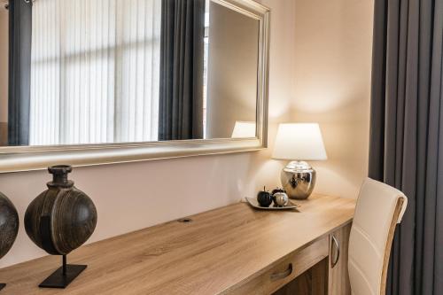 a room with a desk with a mirror and a lamp at Penzion a Restaurace Stará Roudná in Plzeň