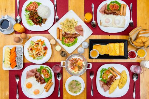 a wooden table with plates of food on it at Le Charme Sukhothai Historical Park in Sukhothai