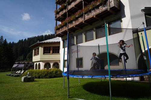 a woman on a trampoline in front of a building at Hotel Bertelli in Madonna di Campiglio