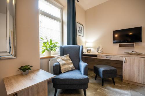 a living room with a chair and a desk at Penzion a Restaurace Stará Roudná in Plzeň