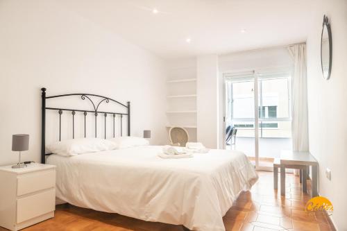 a white bedroom with a large bed and a window at Villa Lola by Cadiz Time in Cádiz