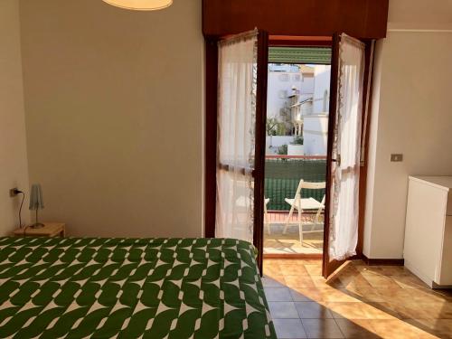 a bedroom with a green bed and a sliding glass door at Villa Filiberta in Grado