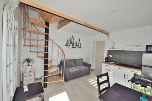 - un salon avec un escalier en colimaçon et un canapé dans l'établissement Le Pré Aux Loups, à Hautot-sur-Mer