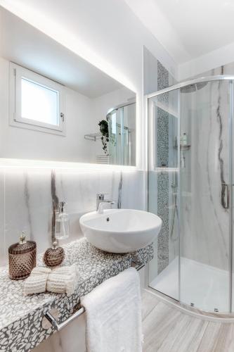 a white bathroom with a sink and a shower at Romagna Suite Hotel in Gatteo a Mare