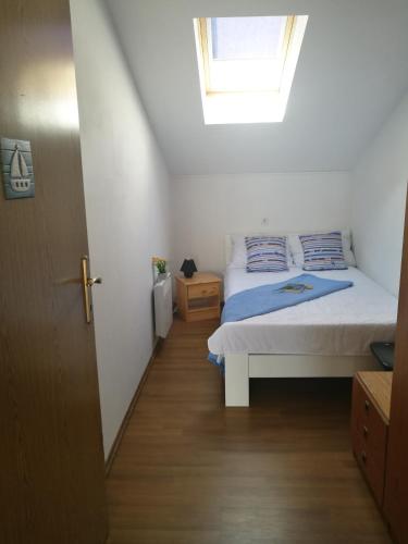 a small bedroom with a bed and a window at Uphill Opatija Apartment in Opatija