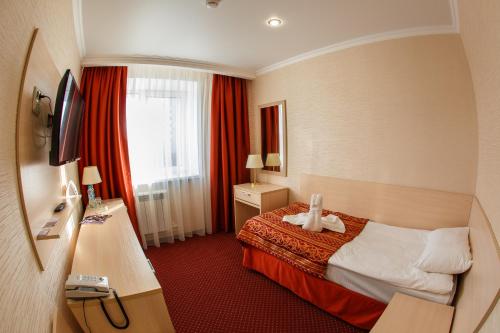 a hotel room with a bed and a window at Hotel Desna in Bryansk