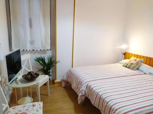 ポンフェラーダにあるApartamento Ponsferrataのベッドルーム1室(ベッド1台、テーブル、テレビ付)