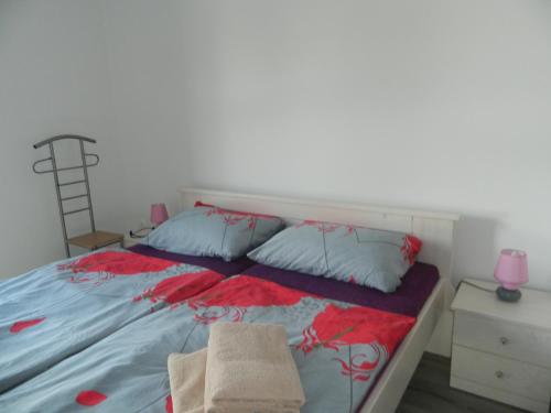 a bed with two pillows and a chair in a bedroom at Apartman Linda in Medulin