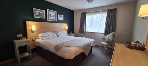 a bedroom with a large bed and a chair at Boat & Horses Inn in Oldham