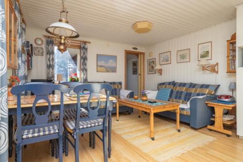 a living room with a table and blue chairs at Strandstugan in Degeberga