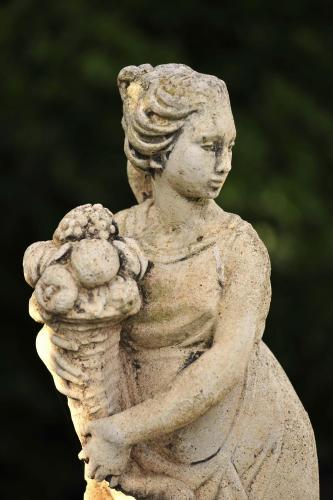 a statue of a girl holding a ball at Hotel Rural Biniarroca - Adults Only in Sant Lluis