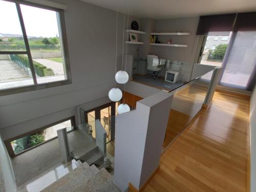 a staircase in a house with a glass table at Sanxenxo Casa Rial 47 con PISCINA CLIMATIZADA in Sanxenxo