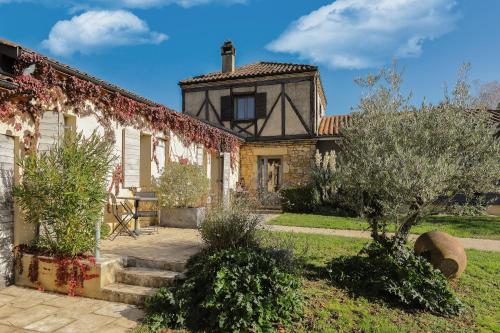 una casa antigua con un jardín delante de ella en Hotel Le Mas de Castel - Piscine chauffee en Sarlat-la-Canéda