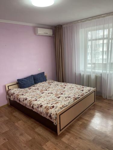 1 dormitorio con 1 cama en una habitación con ventana en Апартаменты на ГОГОЛЯ,460 en Cherkasy