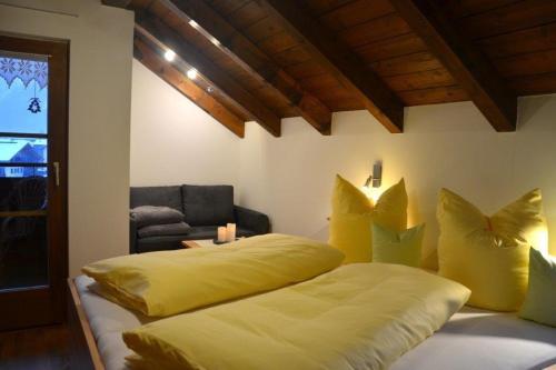メラウにあるAppartement Angelikaのベッドルーム1室(黄色い枕と椅子付きのベッド2台付)