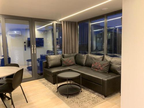 a living room with a leather couch and a table at La Mare Resort in Gothenburg