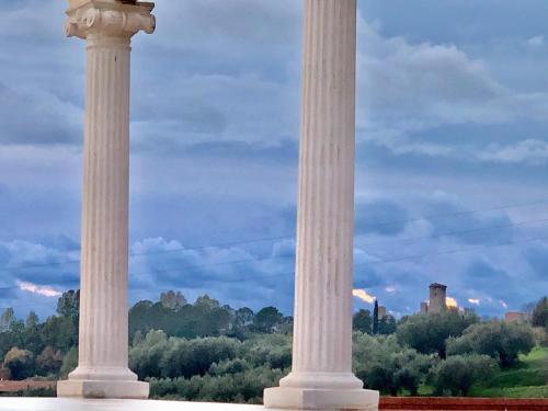 two large white columns in a field with trees at L'incanto di Nausicaa in Ascea