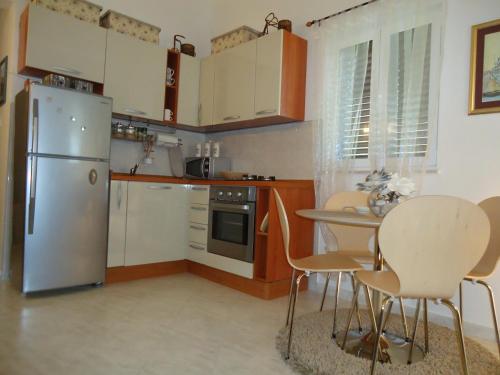 a kitchen with a refrigerator and a table and chairs at Apartment Lucija on the sandy beach in Drvenik Mali