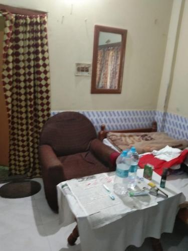 a room with a table and a chair and a bed at Vamoose Nirmala in Kailāshahar