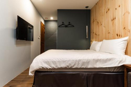 a bedroom with a large bed and a television at Marbordo B&B in Xiaoliuqiu