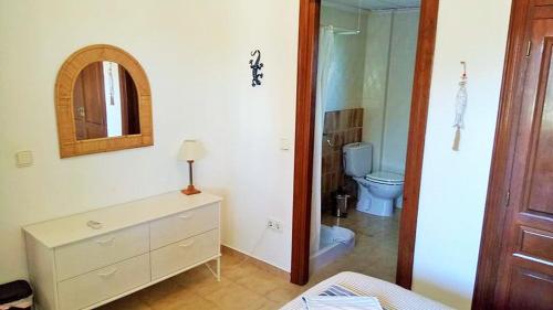 a bathroom with a toilet and a dresser with a mirror at Villa Jansson in Jávea