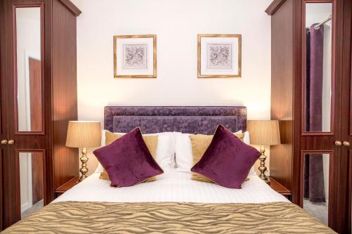 a bedroom with a large bed with purple pillows at Royal Goat Hotel in Beddgelert