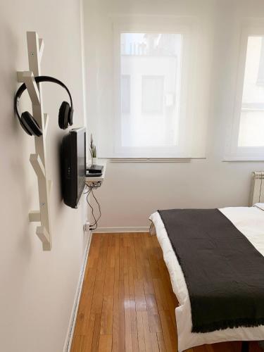 a bedroom with a bed and a tv on a wall at Miu Arena Apartment in Belgrade