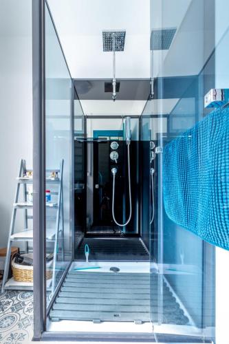 une salle de bain avec une douche avec une porte vitrée dans l'établissement Villa Coppi, au Tréport