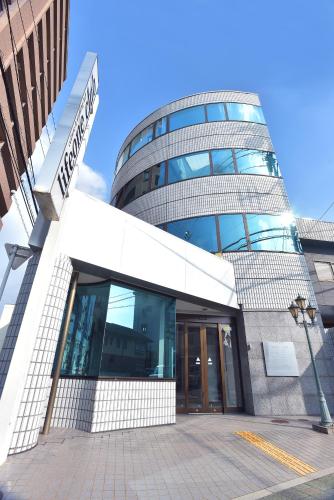 a tall glass building with a sign in front of it at lifeone club in Hiroshima