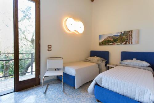 1 dormitorio con 2 camas y balcón en Villa Regina Giovanna, en Sorrento